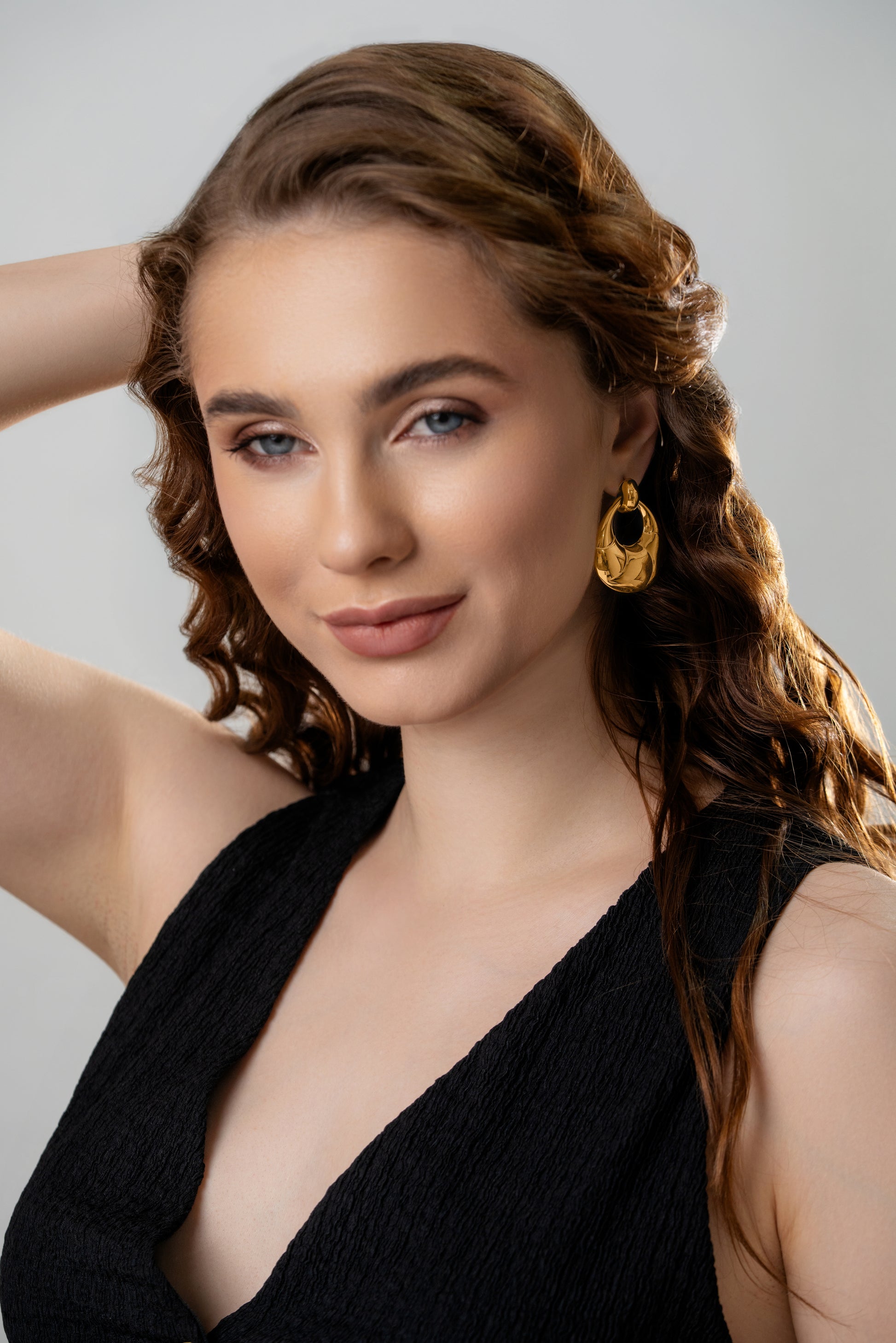 Twirléa Gold Hoops styled on a model with a black outfit, emphasizing their bold, luxurious appeal for formal or evening wear.