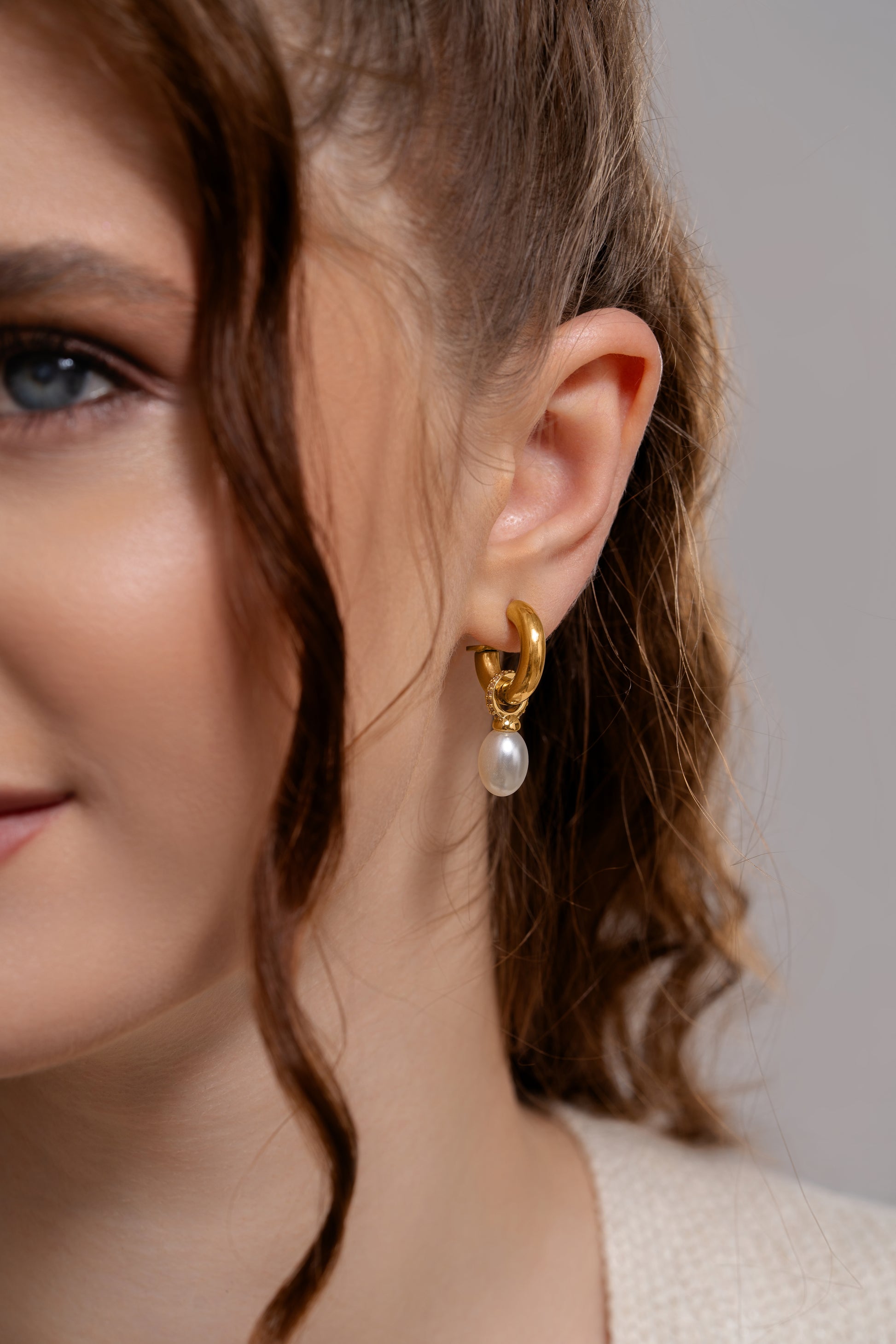 Close-up of Aurora Pearl Drop Hoops on model, highlighting the refined gold hoop and lustrous pearl for a sophisticated look.
