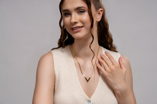 Model wearing Bold V gold necklace, showcasing its elegant V-shaped design, perfect for stylish everyday or formal wear.
