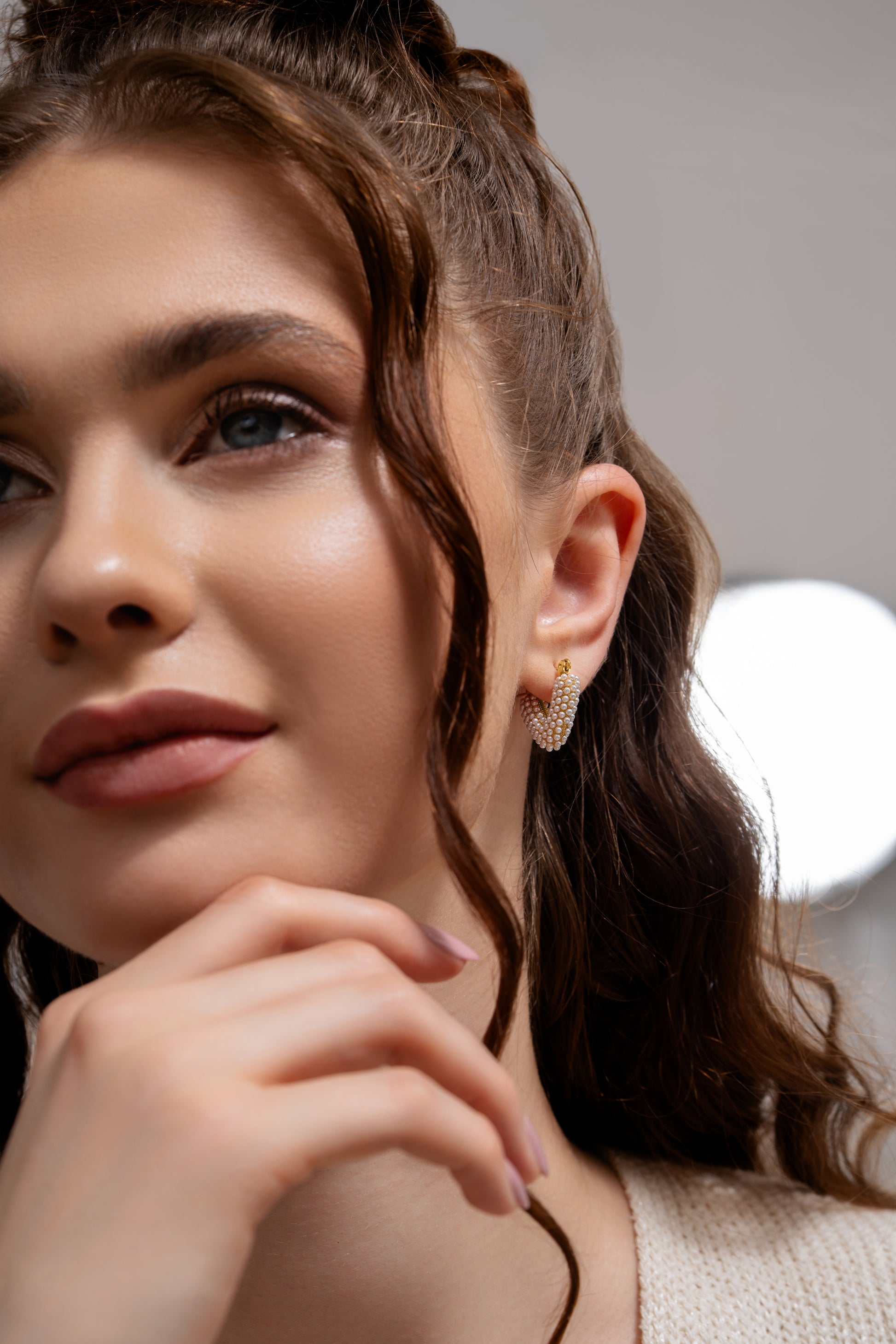 Model wearing Pearl Heart Hoop Earrings showcasing their delicate gold and pearl design, ideal for formal or casual outfits.
