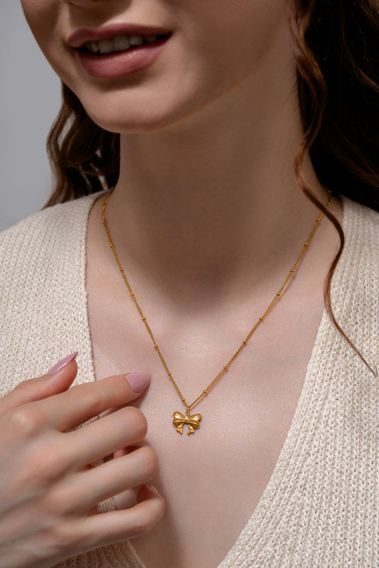 Model wearing Glimmerwing Gold Necklace with butterfly charm, showcasing its refined design and feminine appeal for jewelry lovers.