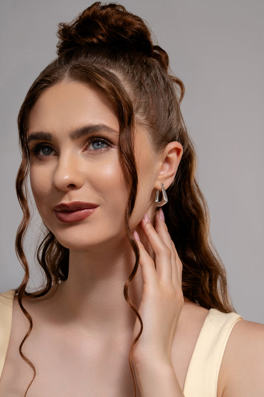 Model wearing U Hoop Earrings in silver, showcasing their bold and stylish look for everyday or evening wear.