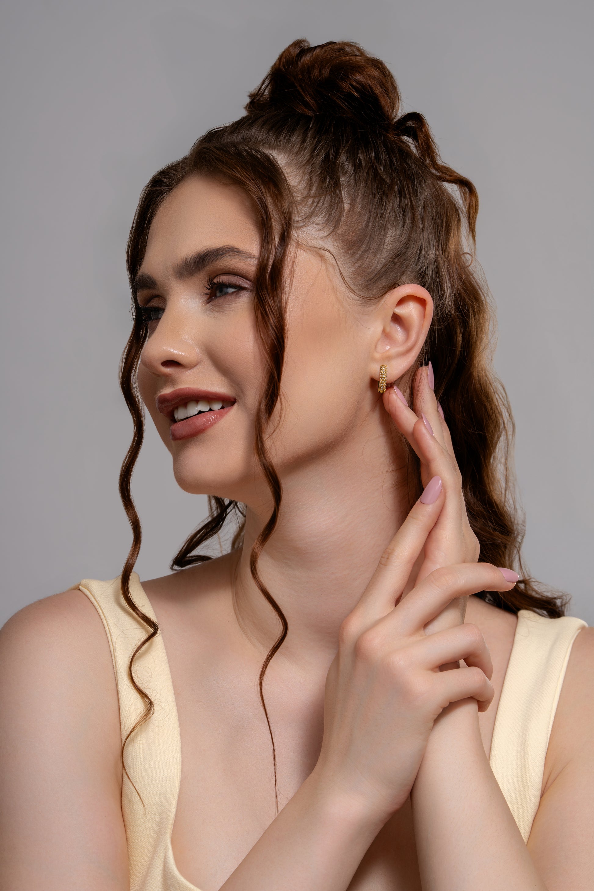 Close-up of model wearing Sparkling Huggie Hoops, highlighting their elegant sparkle and compact design for versatile styling.