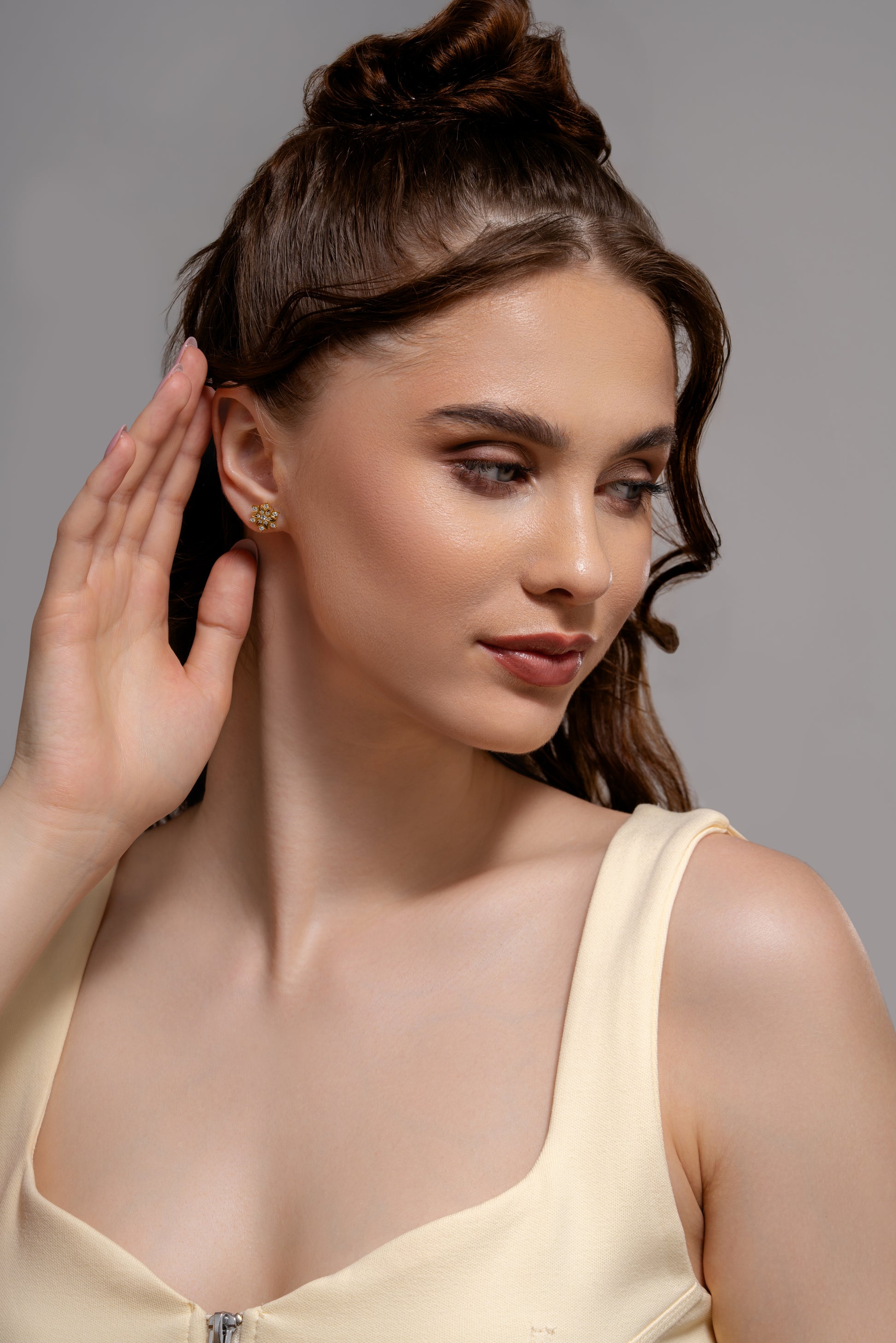 Close-up of model displaying Snowfall Diamond Earrings, highlighting the sparkling diamond accents and delicate snowflake design.