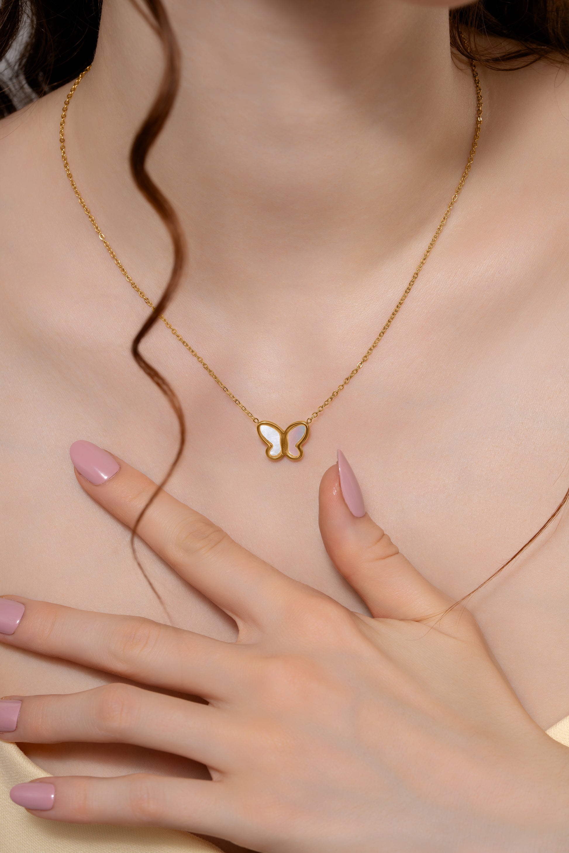 Close-up of Delicate Butterfly Pendant Necklace on model, highlighting the fine gold chain and white butterfly pendant detail.