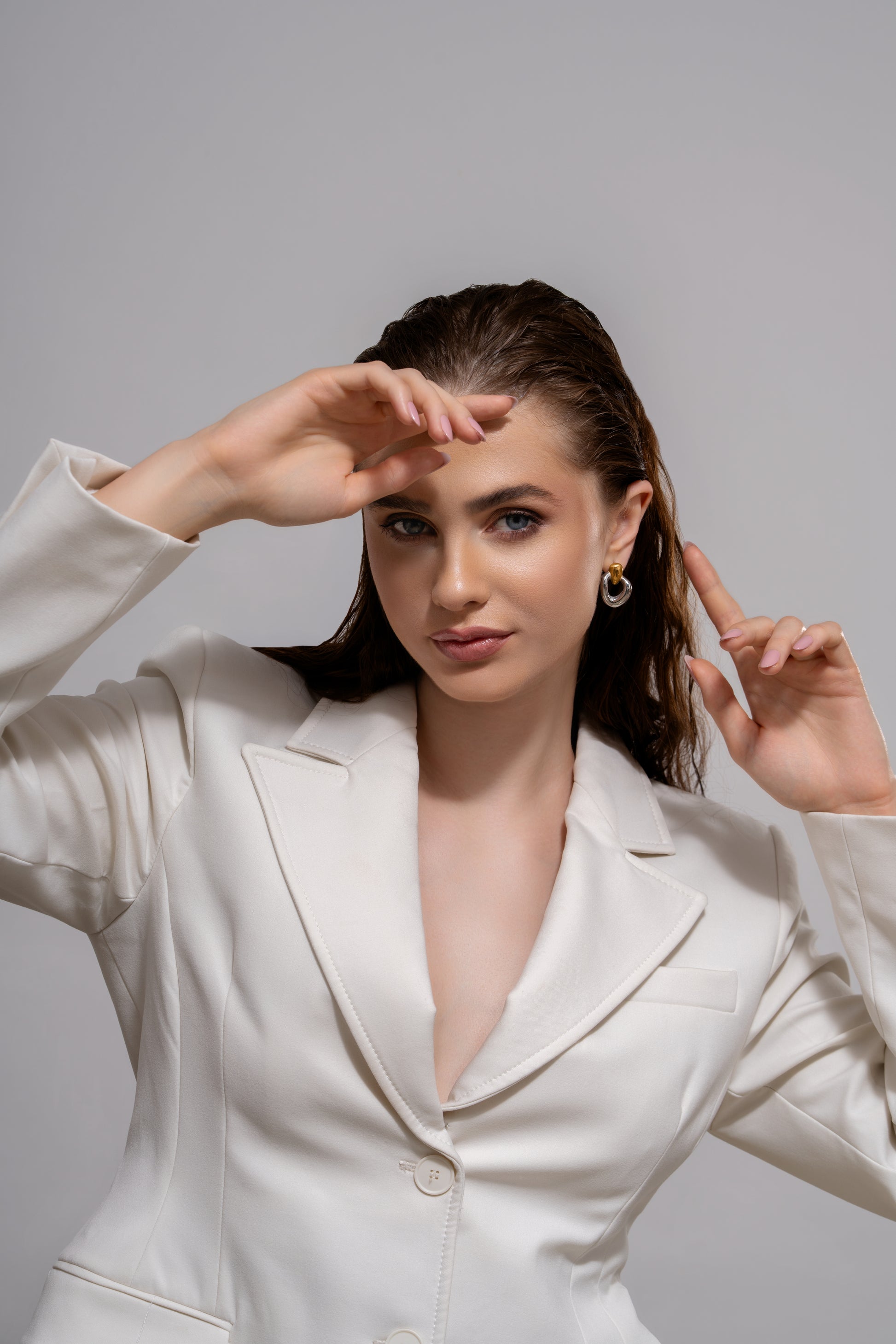 Model wearing Orbit Dual-Tone Sculpted earrings styled with a white blazer, showcasing elegant contrast and bold fashion appeal.