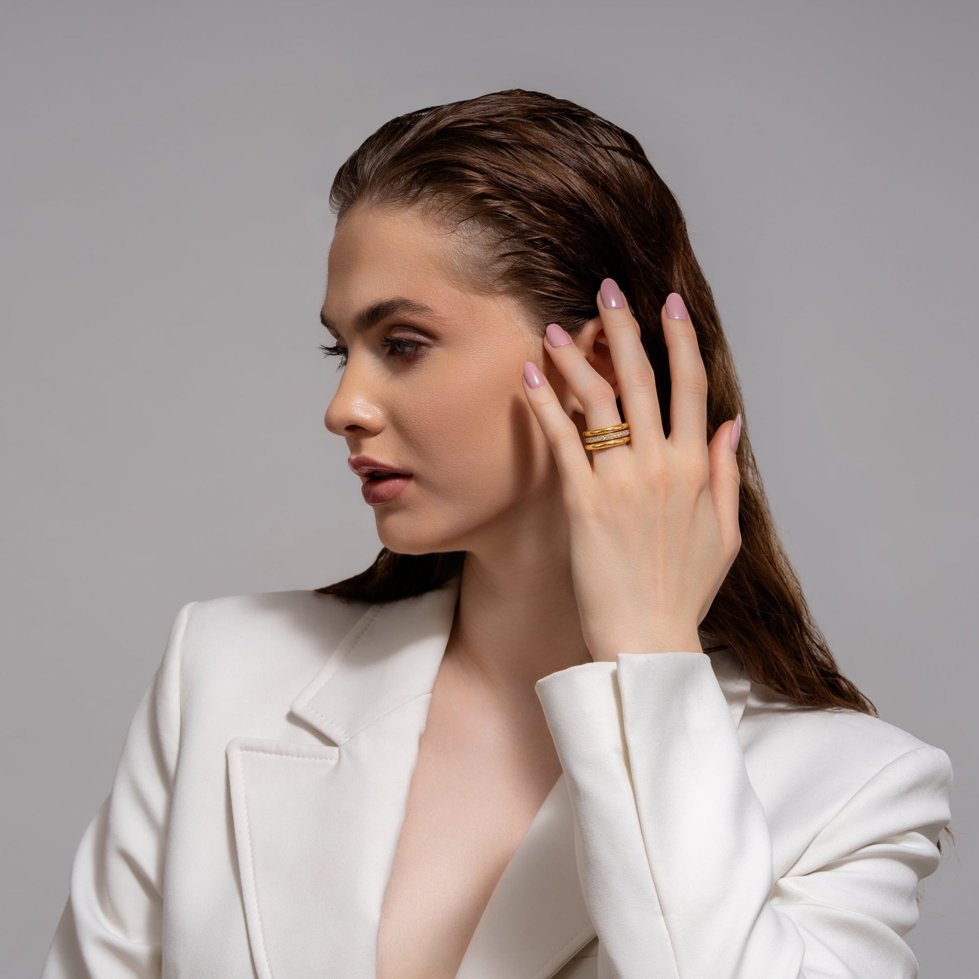 Model wearing Celestial Trio gold ring set on index finger, showcasing elegant stacked design for luxury fashion styling.