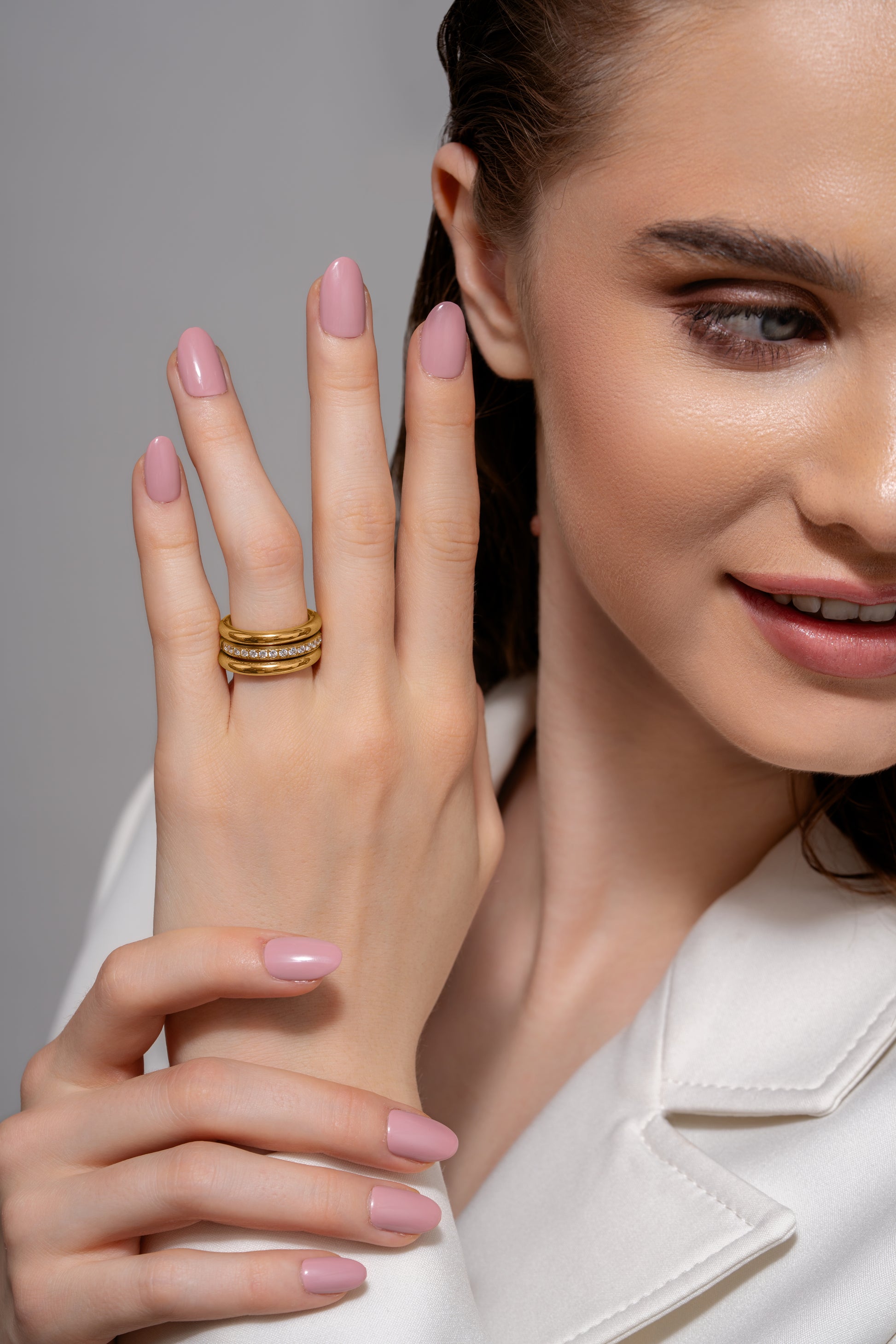 Close-up of Celestial Trio gold ring set on model's hand, highlighting the sparkling pavé diamond band in a chic stacked arrangement.