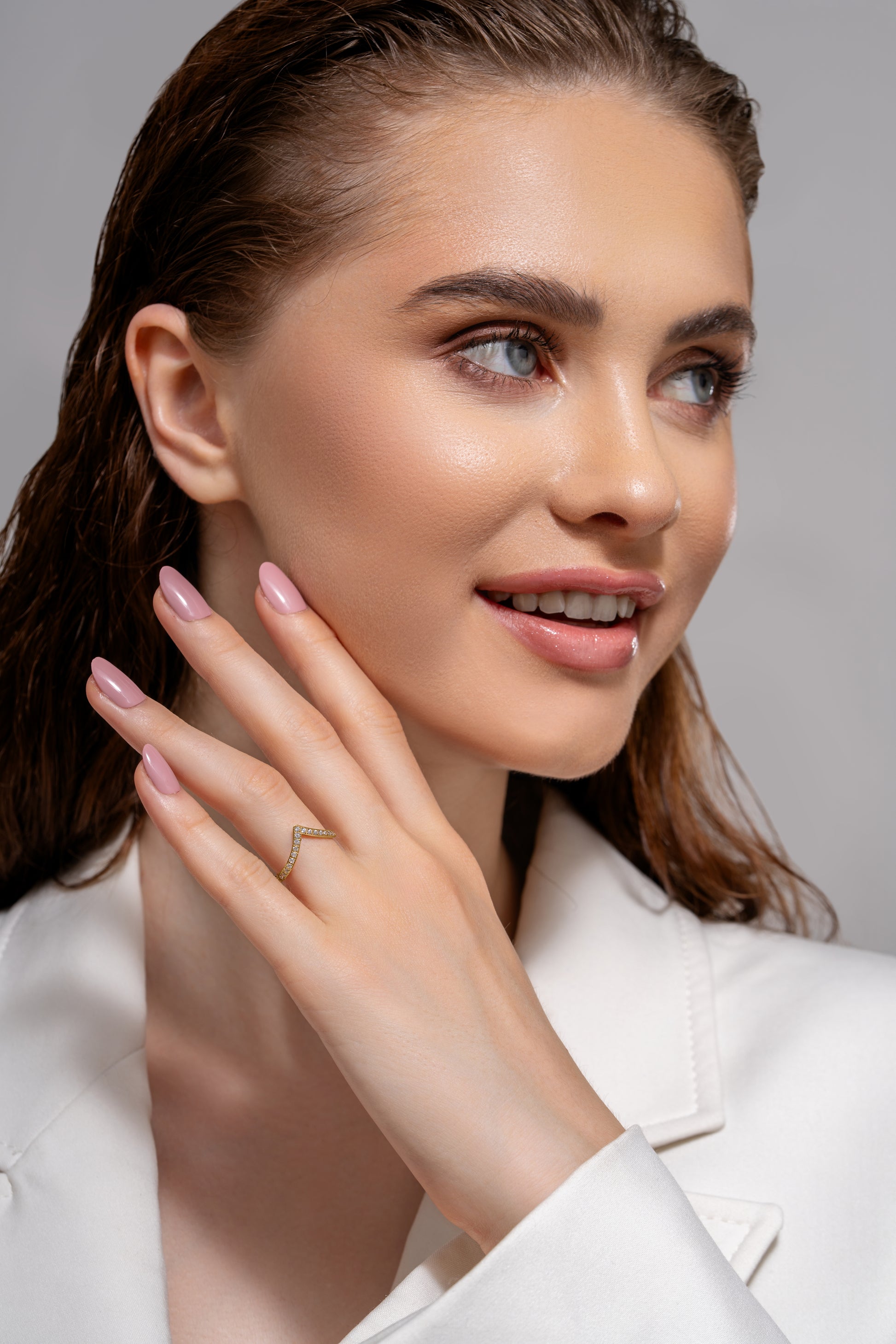 Model wearing The Velo Ring, showcasing its delicate V-shaped gold design with sparkling stones, perfect for fashion-forward accessories.