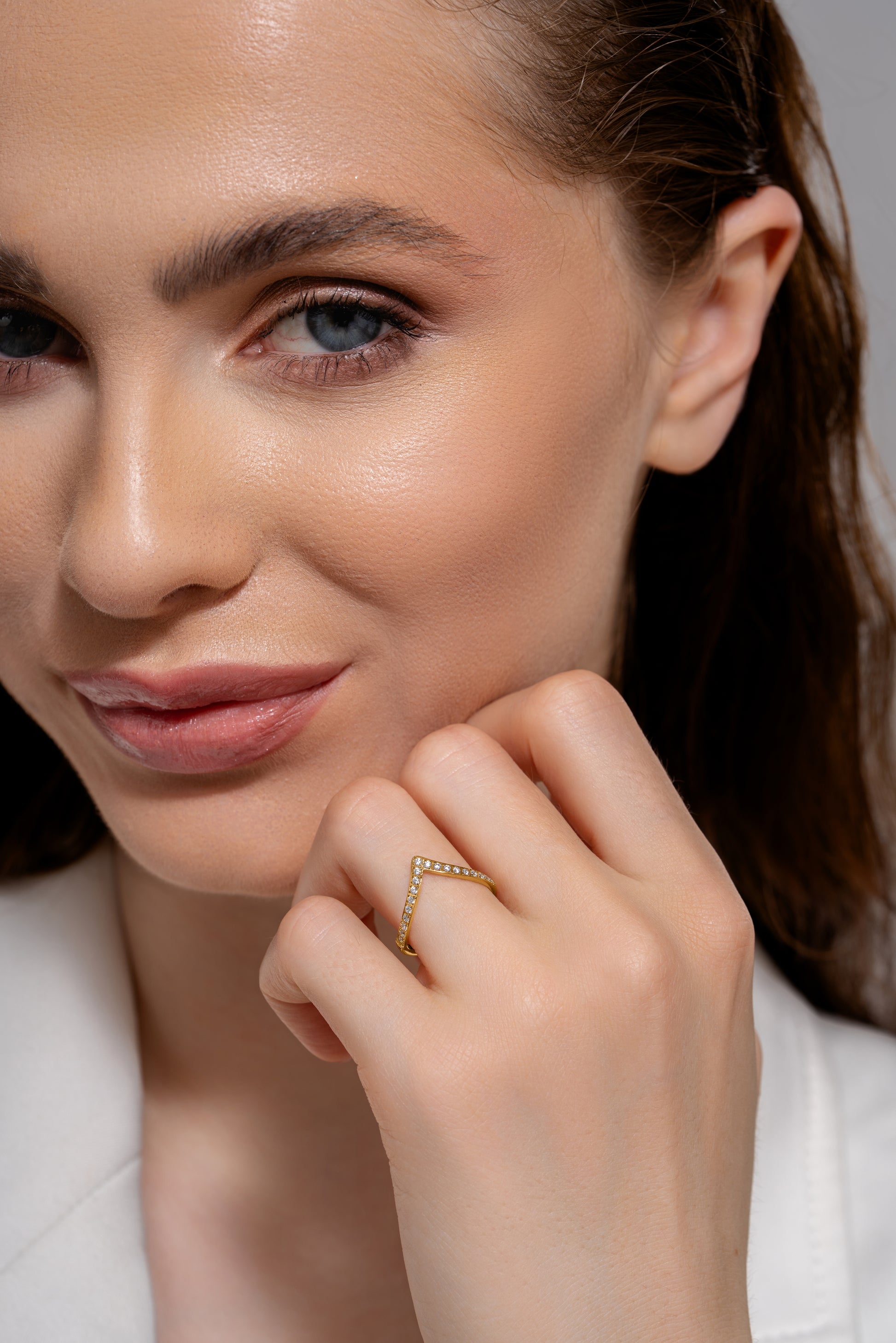 Close-up of The Velo Ring on model’s hand, highlighting the gold V-shape and embedded gemstones for a refined jewelry look.