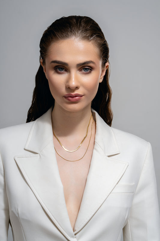Layered Duo Necklace with dual gold chains showcased on a model in a white suit, perfect for modern fashion jewelry collections.