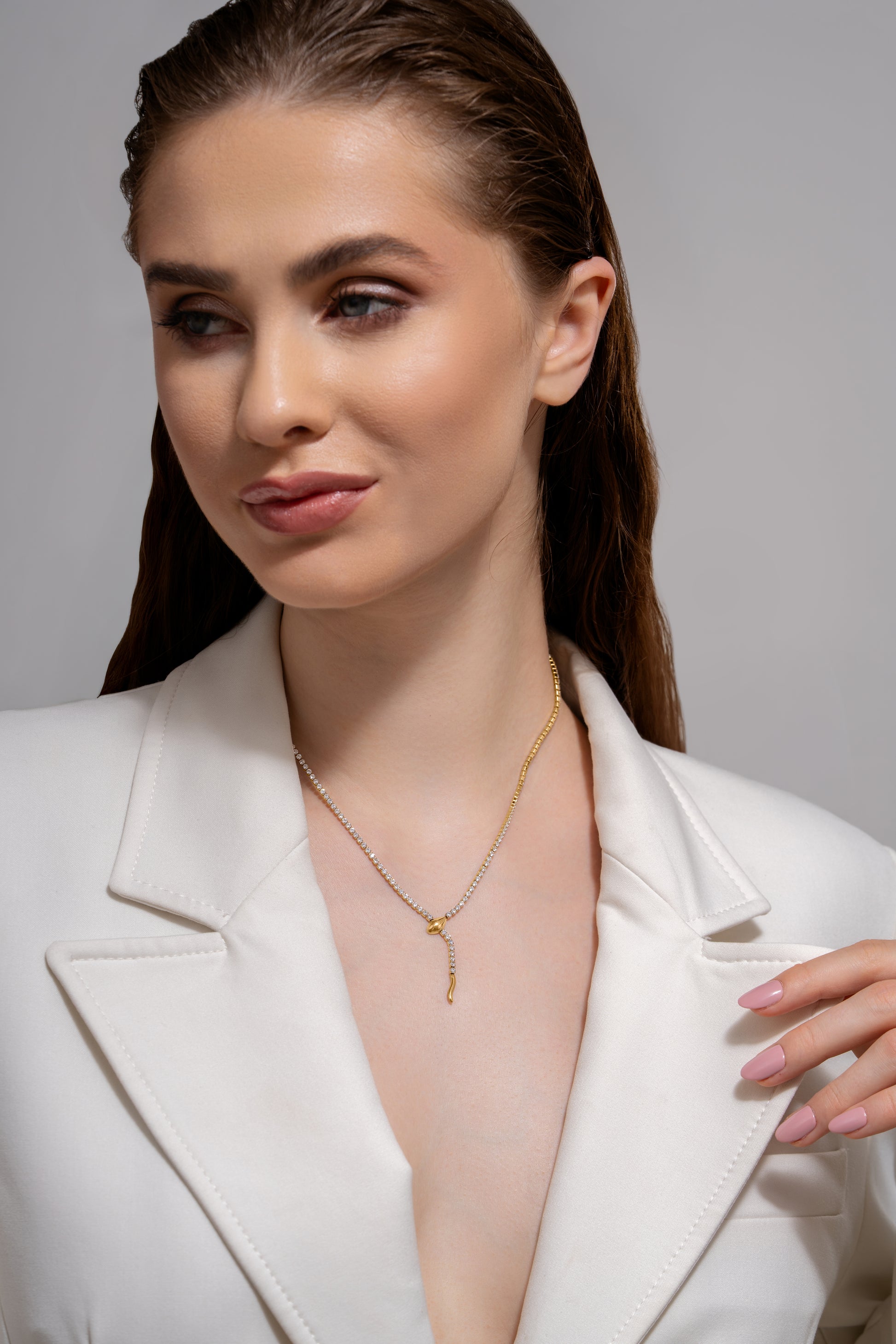 Serpent's Embrace Necklace styled on a model in a white blazer, highlighting the unique snake design and dual-tone chain for chic accessorizing.