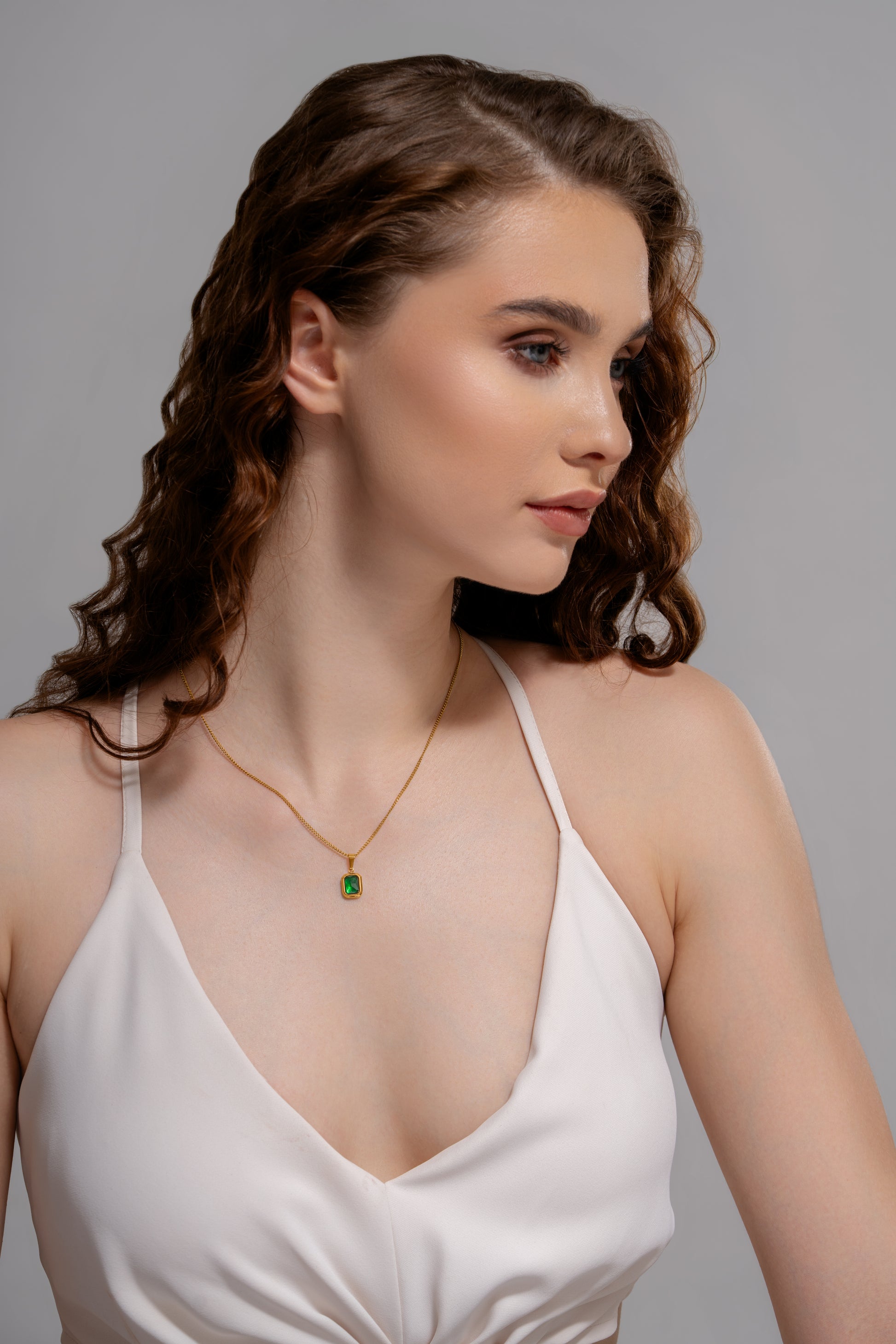 Model wearing Classic Emerald Necklace with a white dress, highlighting the pendant's elegance and suitability for special occasions.