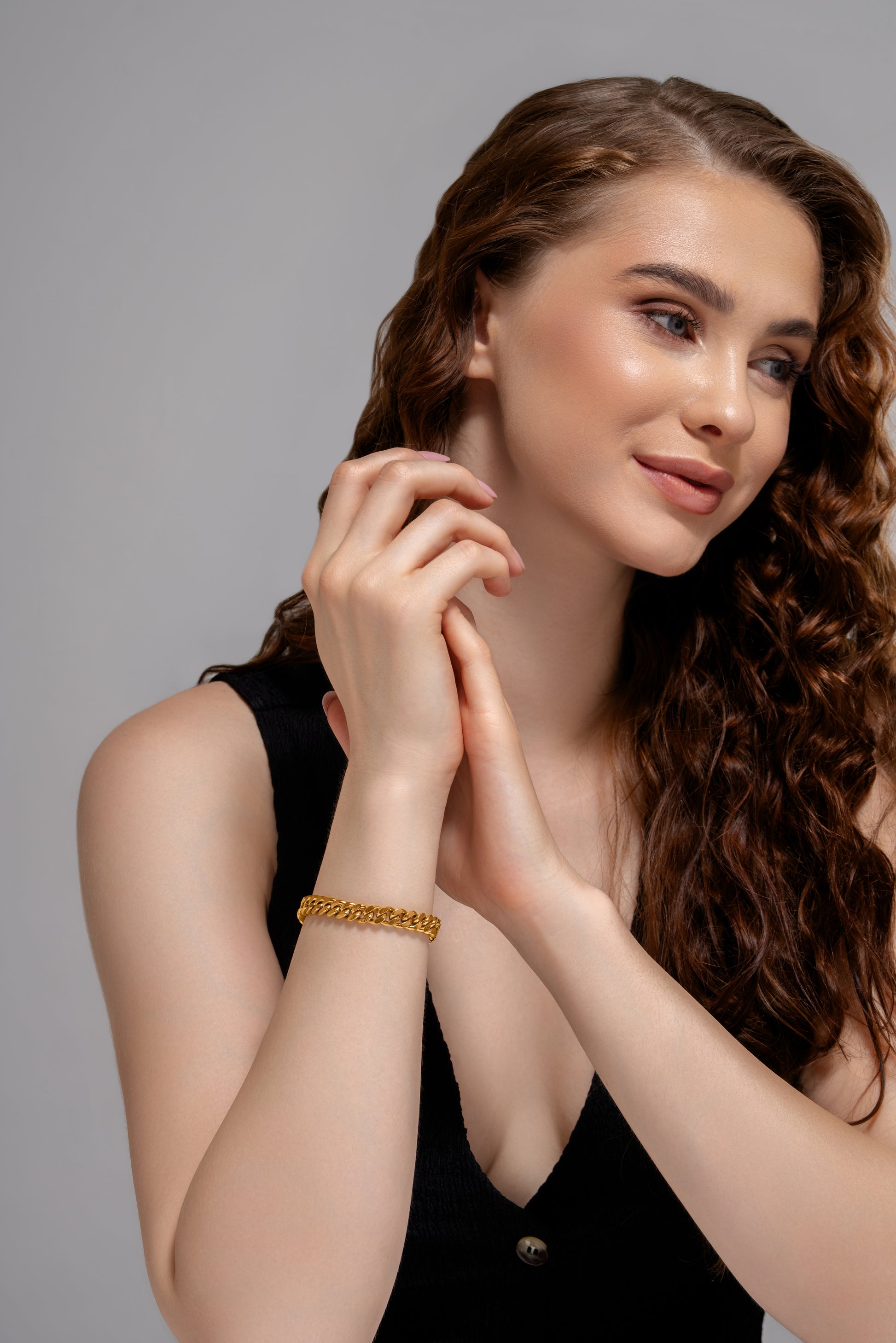 Bold Mini Link Bracelet worn by model with curled hair, emphasizing its bold gold links as a statement jewelry piece.