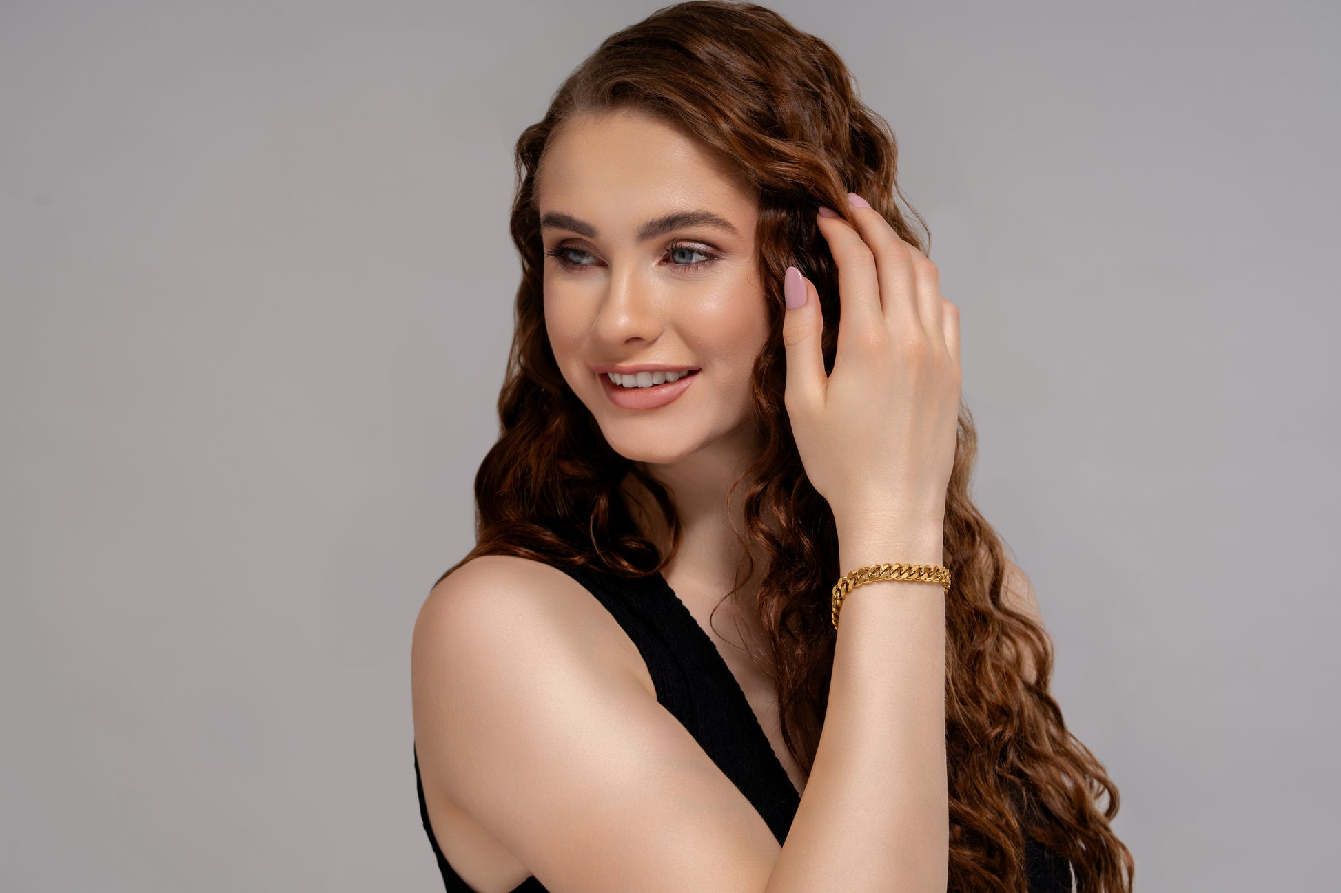 Model wearing Bold Mini Link Bracelet in gold, styled with a sleeveless black top, showcasing its elegant and modern design.