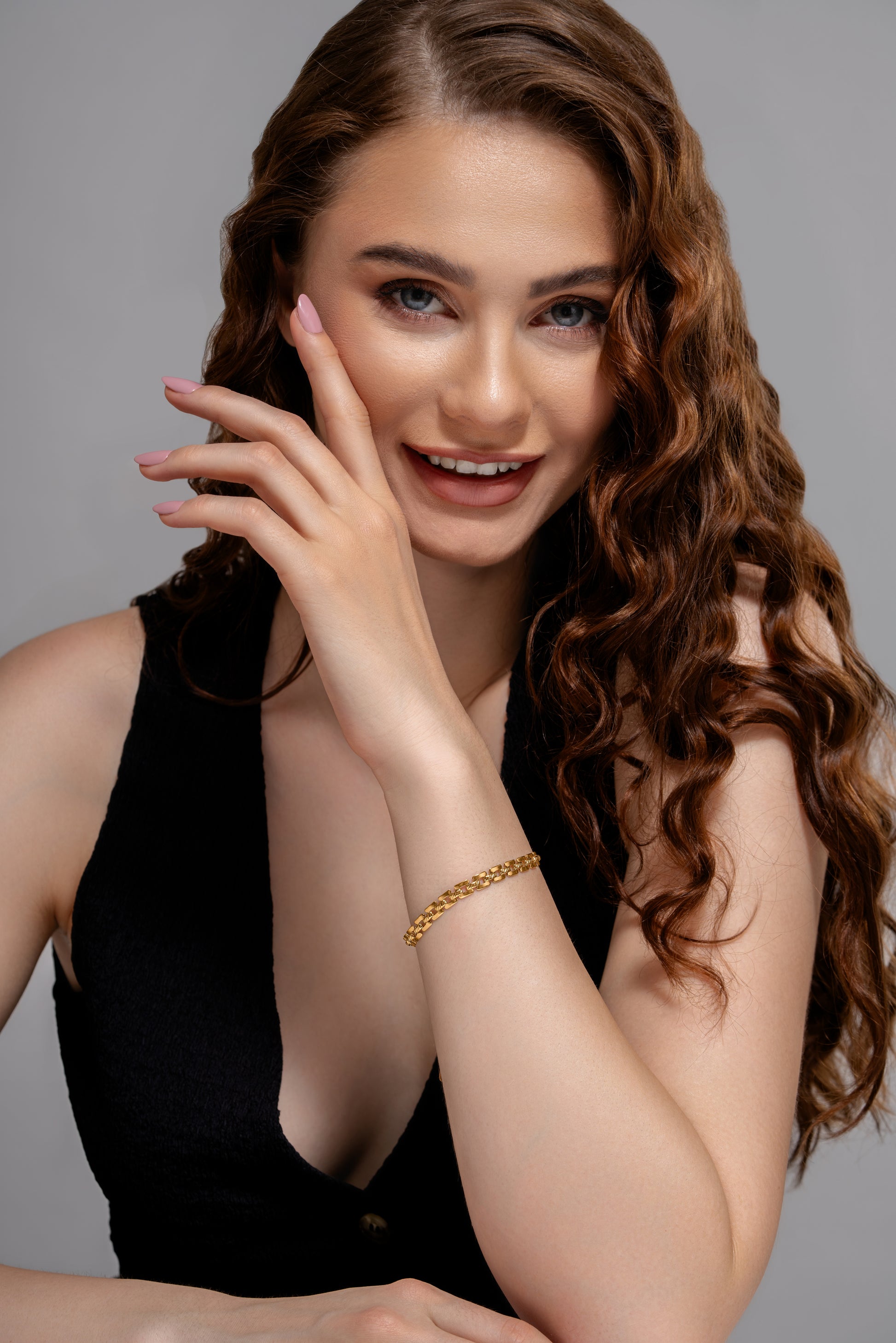Smiling model showcasing Stackable Radiance Bracelet, highlighting its sleek gold finish and stackable appeal for daily wear.