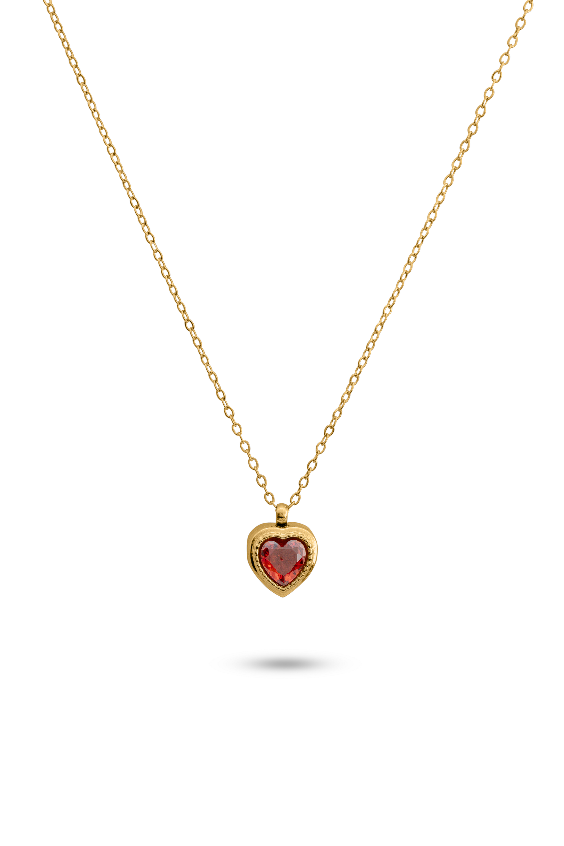 Crimson Heart Pendant featuring a red heart-shaped gemstone set in a gold bezel on a delicate gold chain. Ideal for romantic jewelry collections.