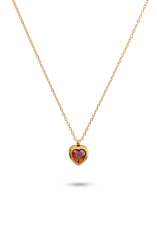 Crimson Heart Pendant featuring a red heart-shaped gemstone set in a gold bezel on a delicate gold chain. Ideal for romantic jewelry collections.