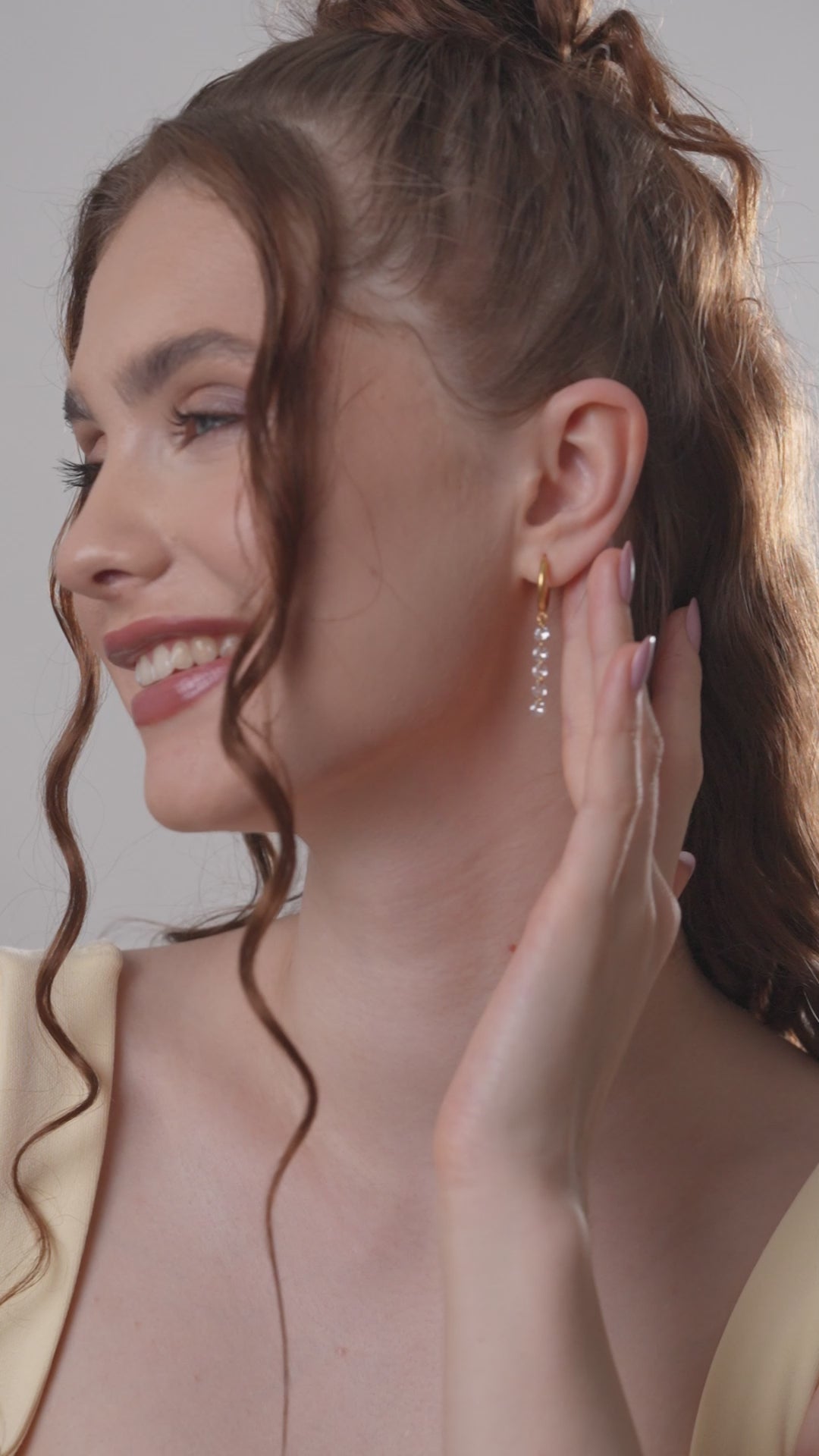 Loop Crystal Chain Hoops on smiling model, emphasizing the sparkling crystal chain and gold hoop design for trendy accessorizing.